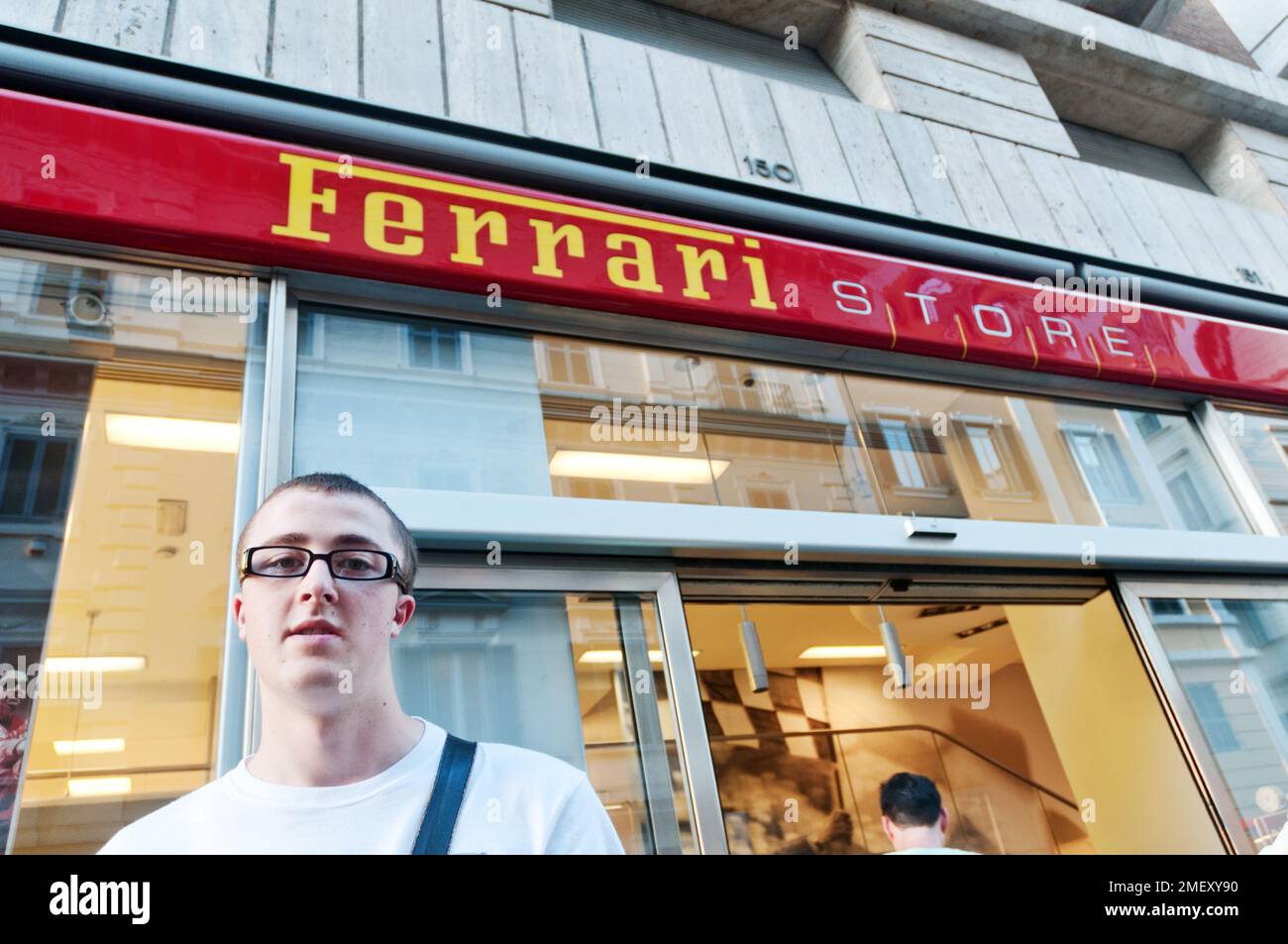 A young man outside the Ferrari Store in Rome, Italy Stock Photo
