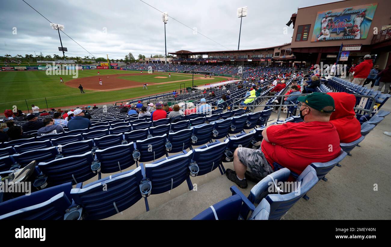 A limited number of socially distanced baseball fans watch a spring