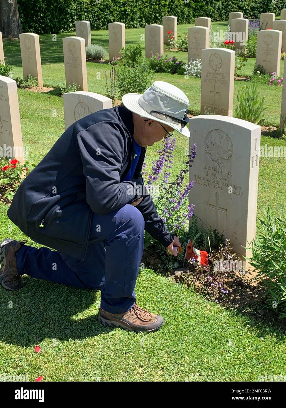 Senior man visiting gravesite of Canadian Soldier (Calgary Regiment), at Foiano della Chiana Commonwealth War Cemetery, Tuscany, Italy. Stock Photo