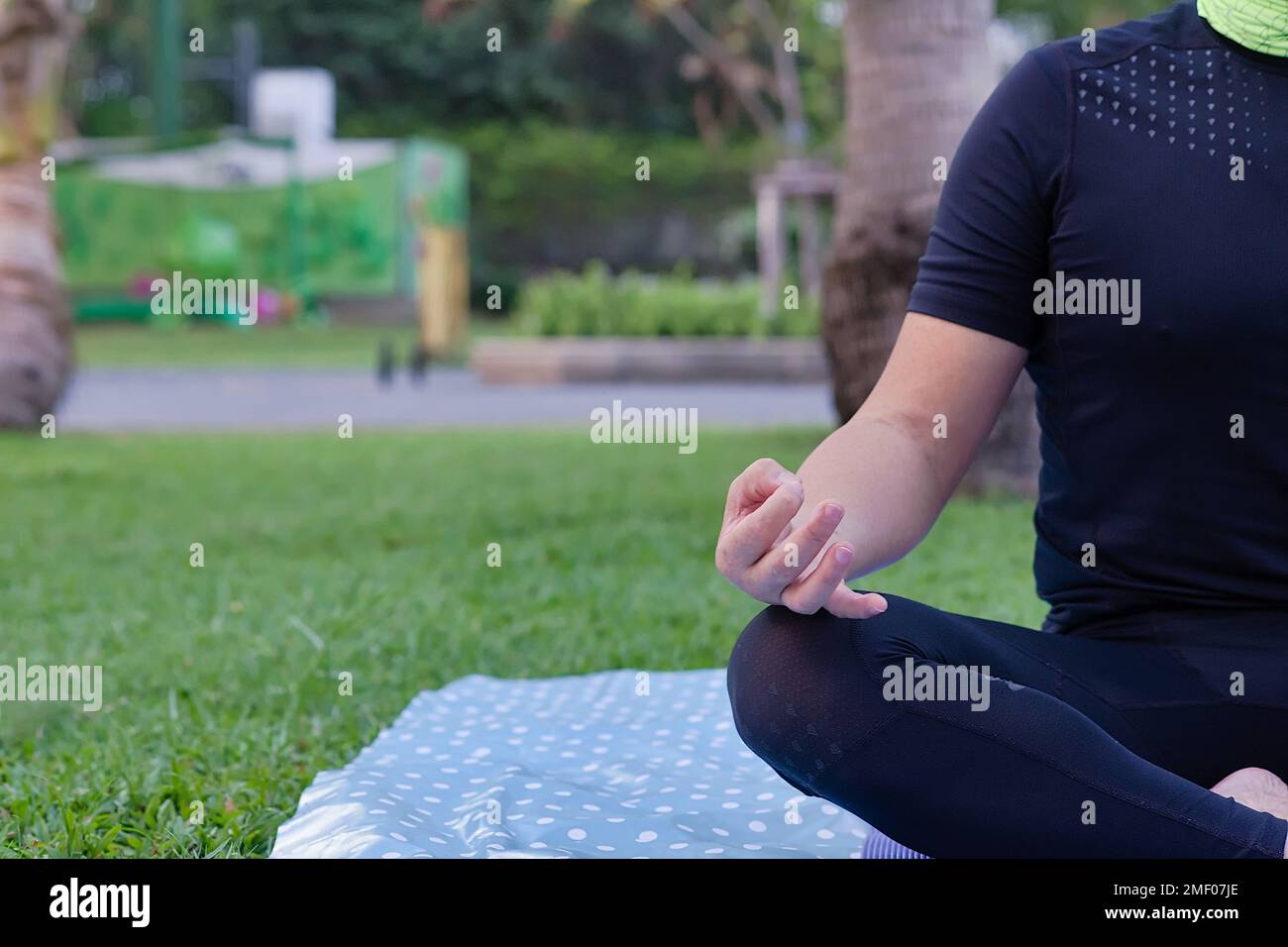 Close-up half body part of Asian man who playing yoga practice on public park in the morning for help body become stronger and immunity to disease Stock Photo