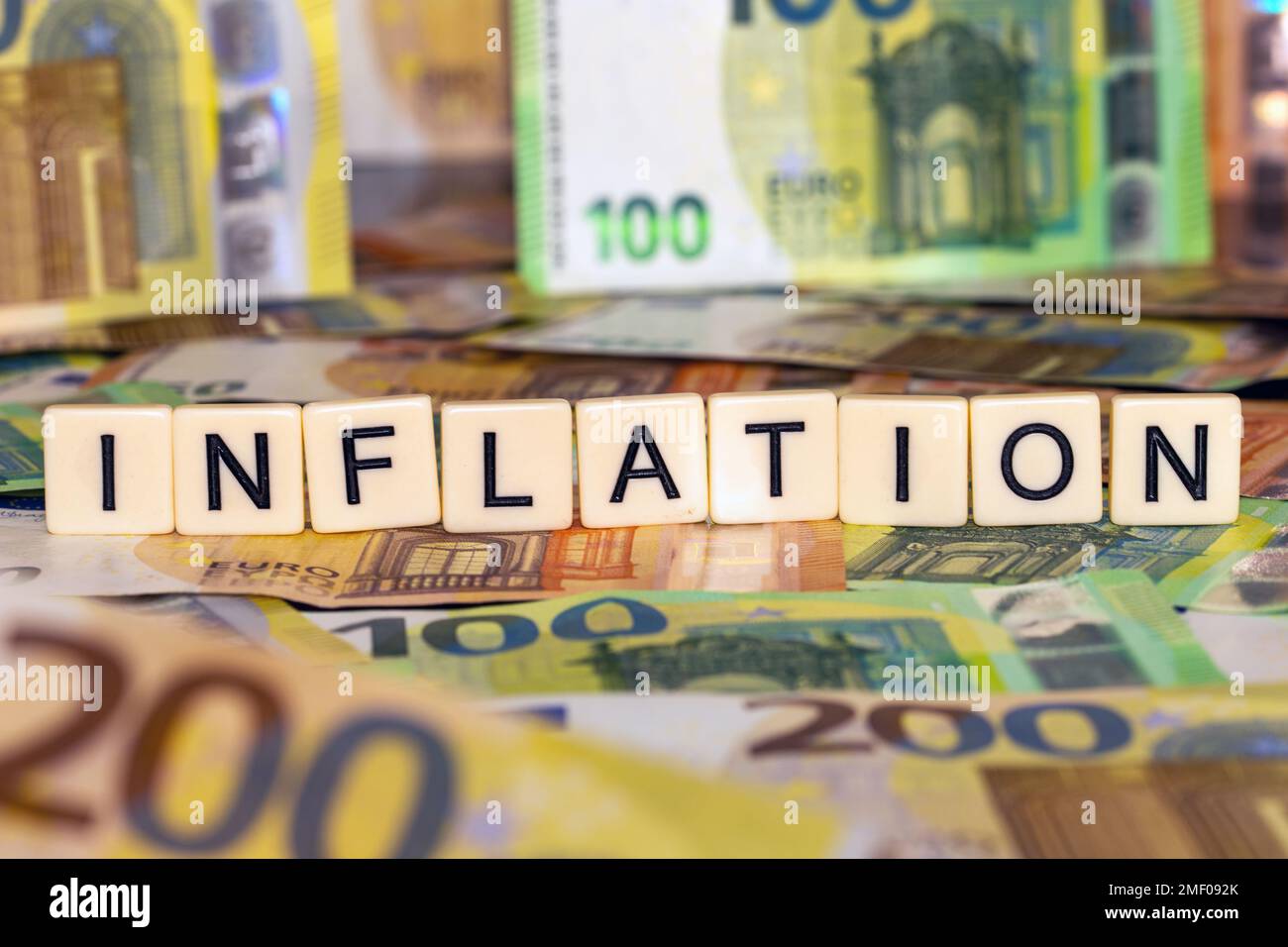 Symbol image of inflation: Euro banknotes and letter cubes showing the word inflation Stock Photo