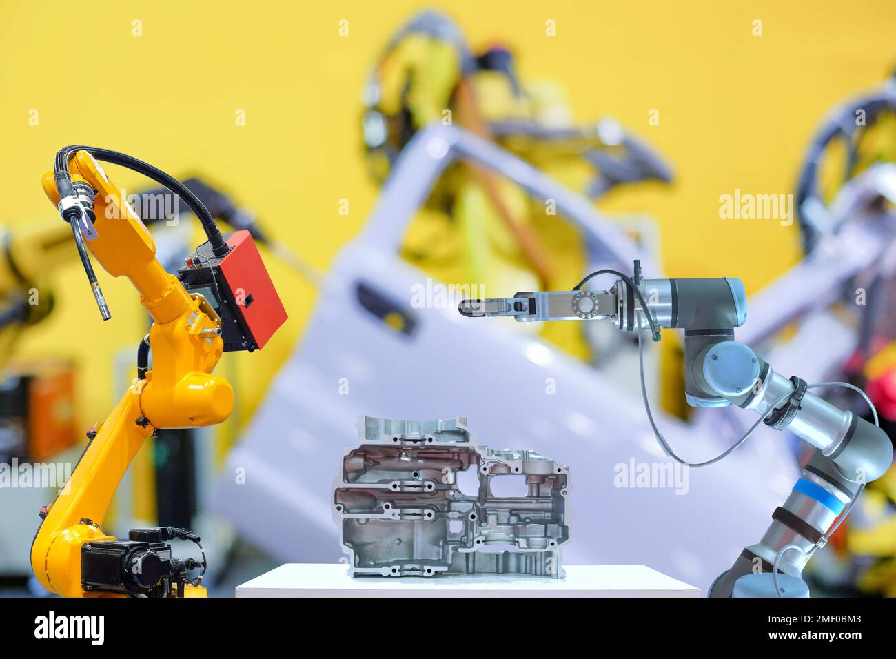 Industrial robotic welding and gripping robot working with metal part on blurred smart car factory background Stock Photo