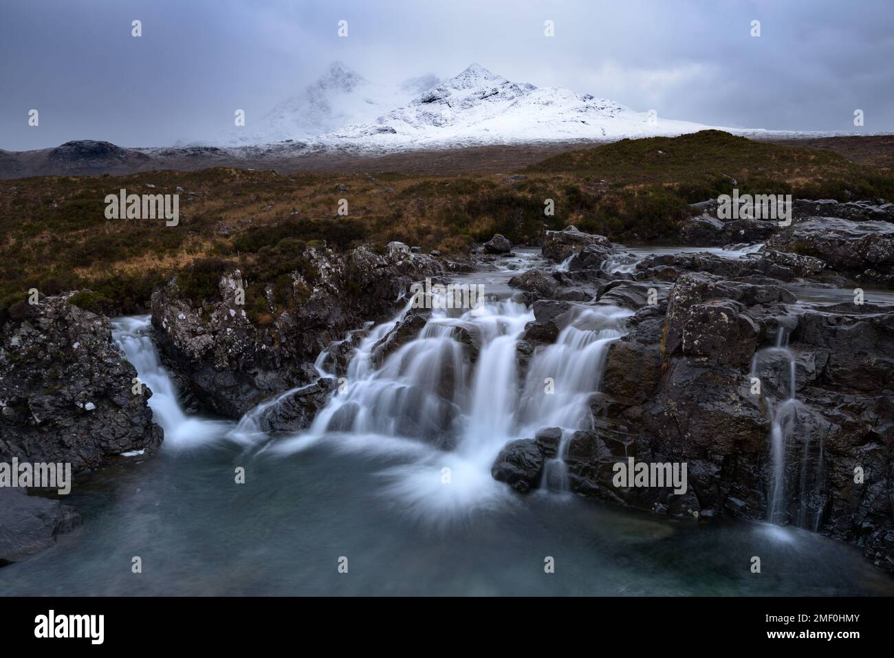 Beautiful waterfall at Sligachan with view of snowcapped Cuillin mountain range, Isle of Skye, UK. Stock Photo