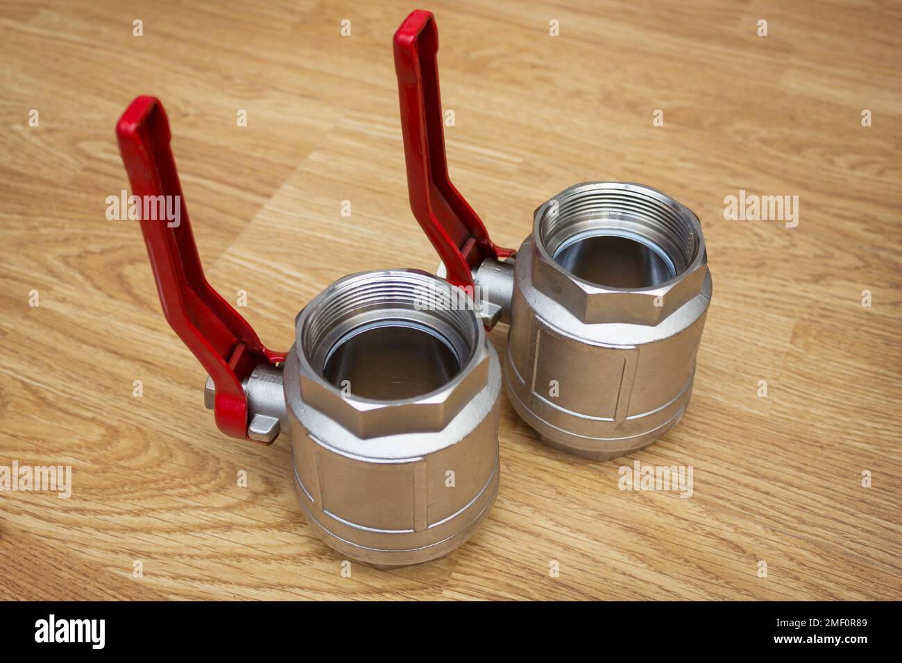 Two large 2inch ball valves with a red lever handle on a table Stock