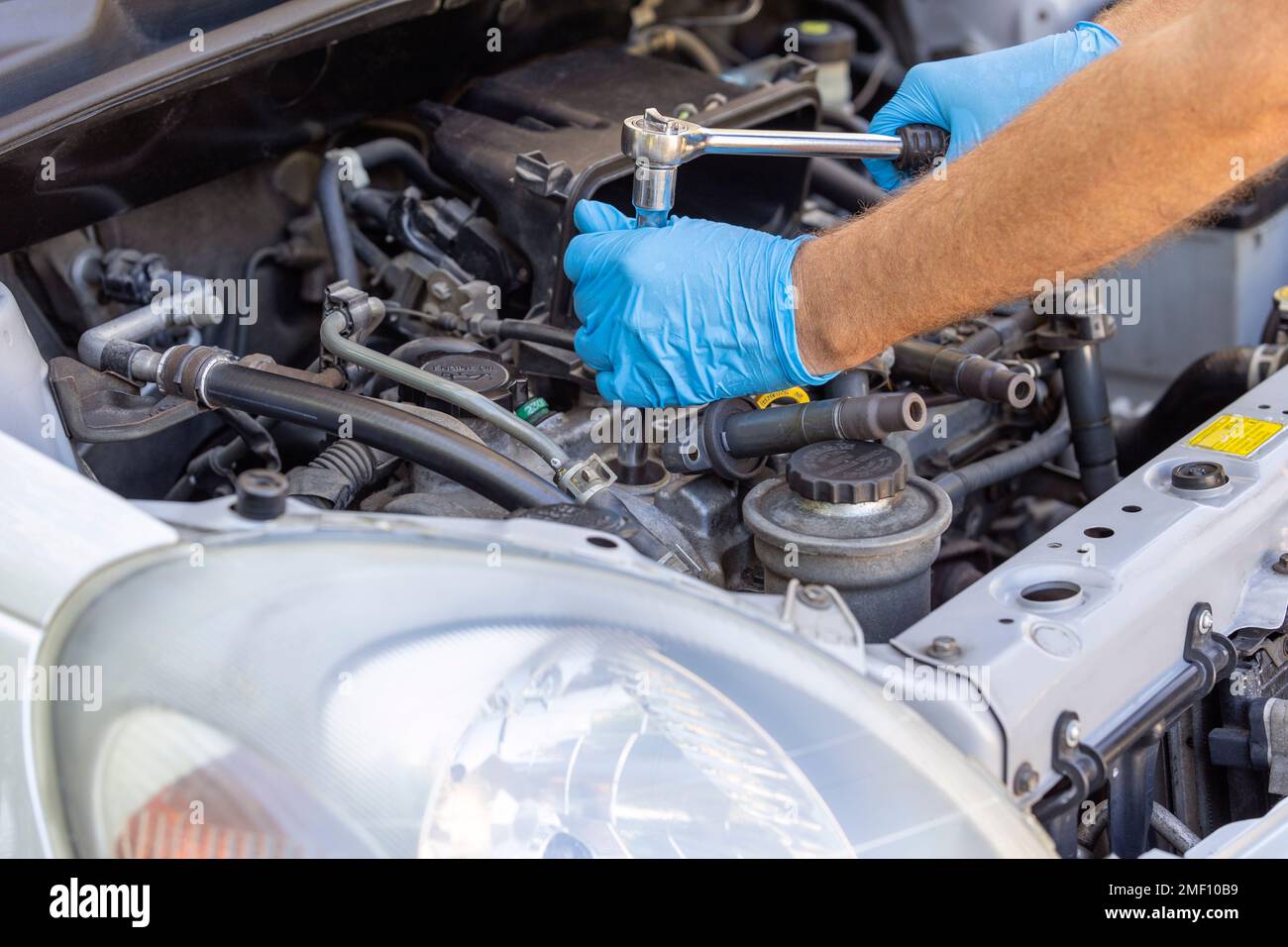 Car spark plug and ignition coil change or replacement. Repairing of vehicle engine Stock Photo