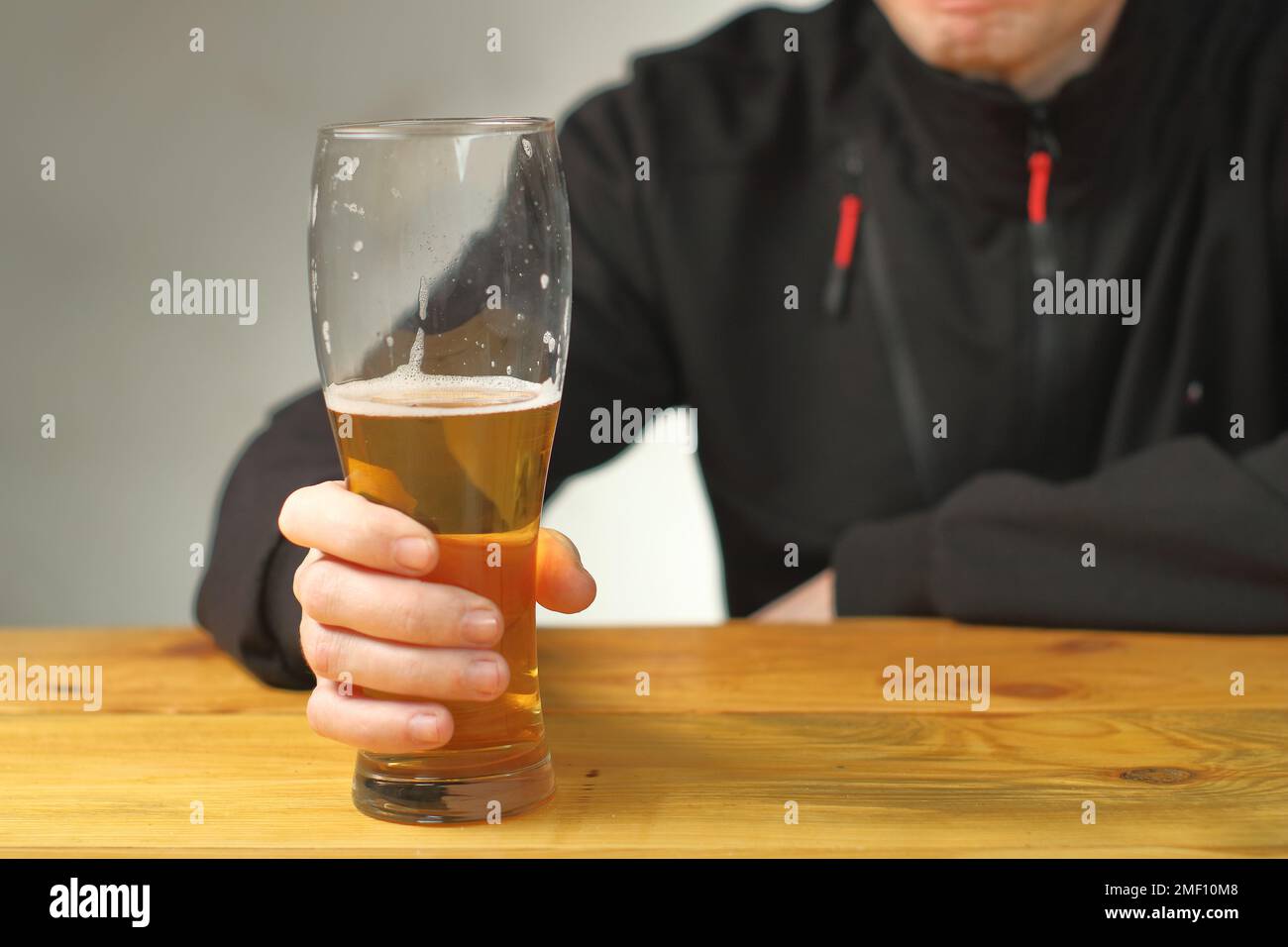 mug with beer in hand on the table and the background of the person Stock Photo