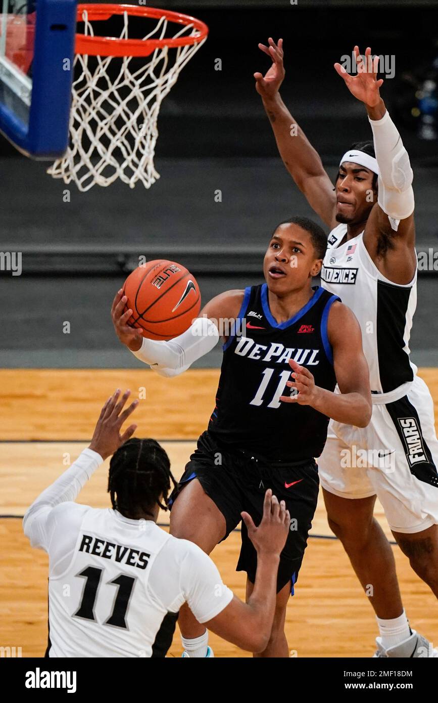 DePaul's Charlie Moore, center, drives past Providence's David Duke ...
