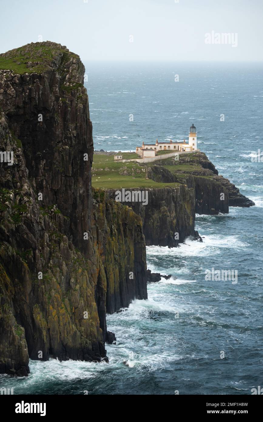Rough waves crashing onto cliffs surrounding Neist Point Lighthouse on The Isle of Skye, Scotland, UK. Stock Photo