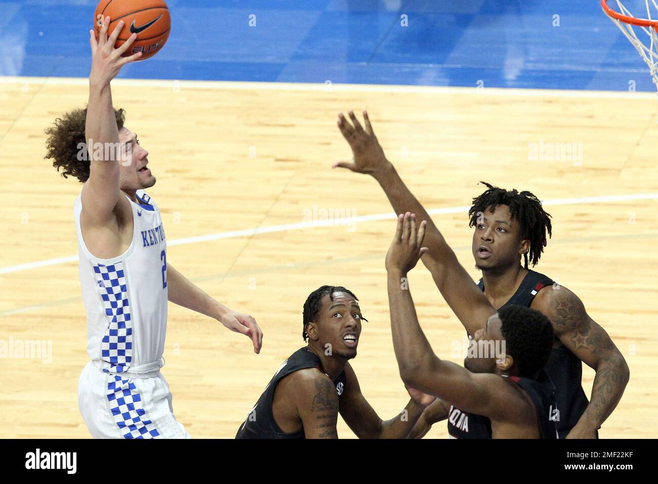 Kentucky's Devin Askew, left, shoots over South Carolina's, from left, T.J. Moss, Trae Hannibal