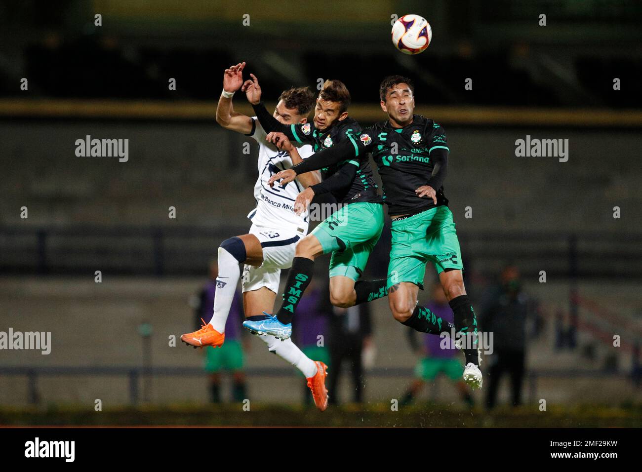 Pumas' Nicolas Freire, left, jumps for a header with Santos' Ronaldo  Prieto, center, and Juan Otero during a Mexican soccer league match at  University Olympic Stadium in Mexico City, Thursday, March 4,