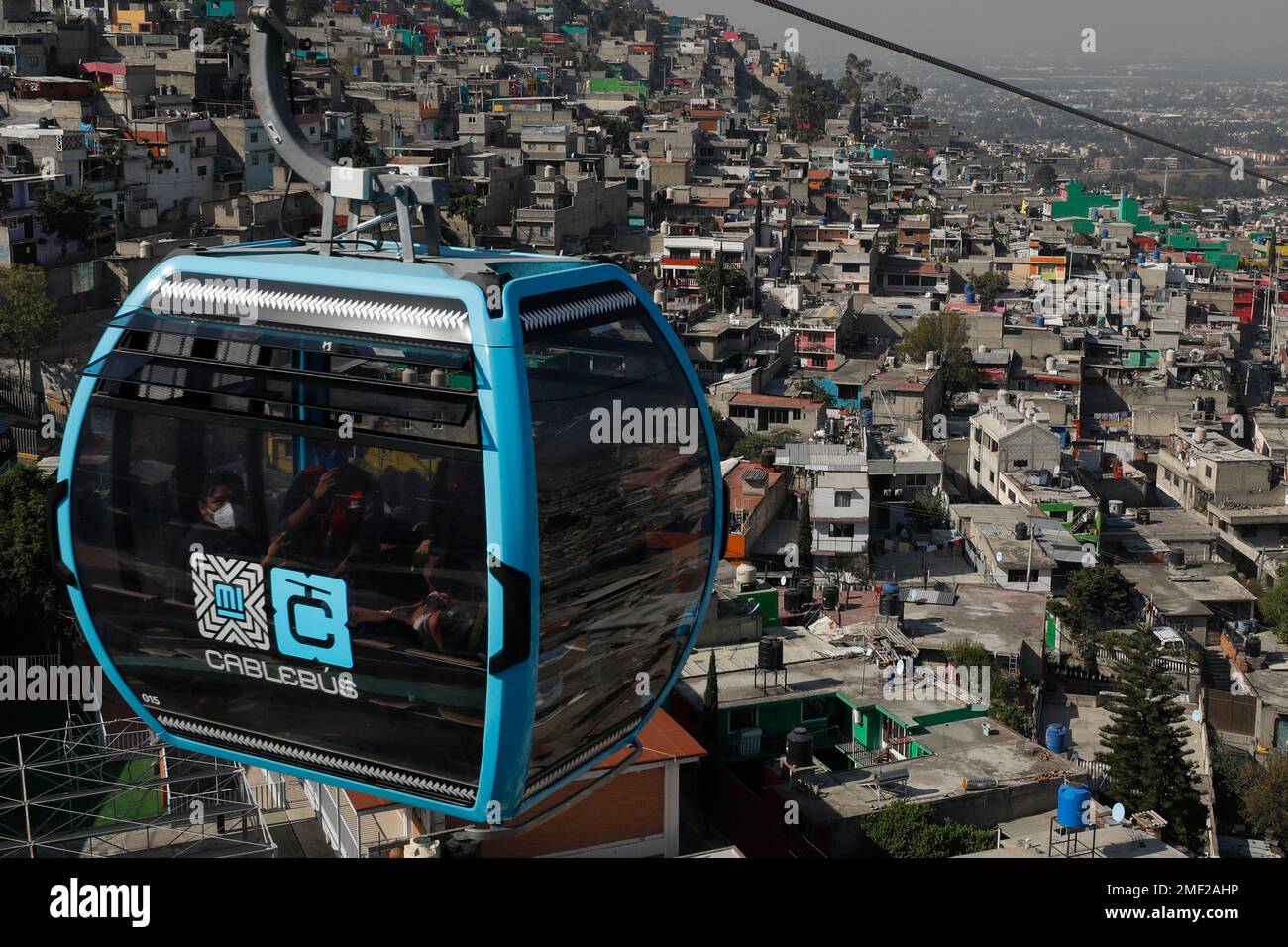 Officials and journalists ride in a cable car between the Campos Revolucion  and Tlalpexco stations, during the inauguration of a new aerial public  transit system dubbed the Cablebus, in the Cuautepec neighborhood