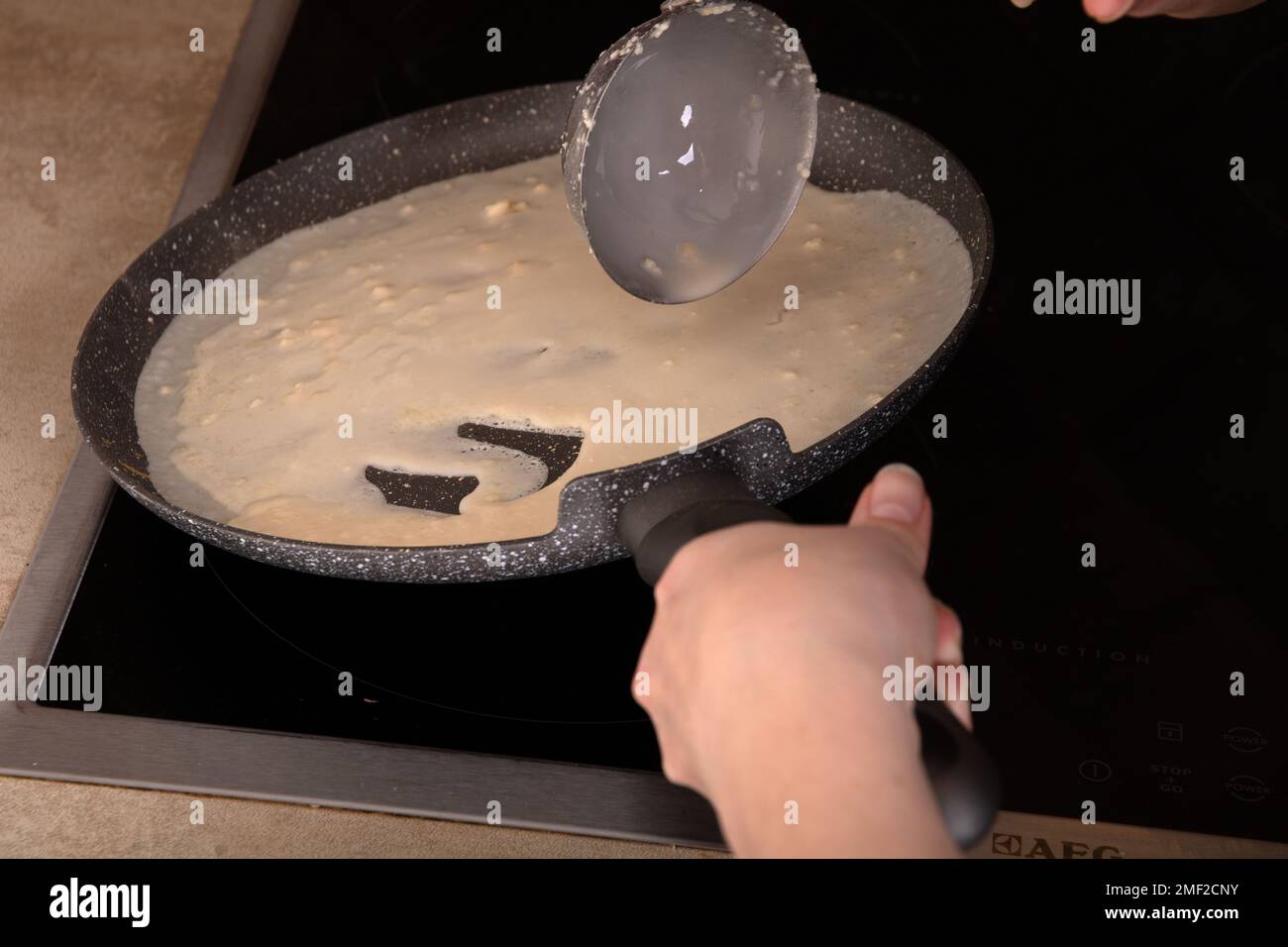 photo of the batter pouring into the pan, there is a hand in the frame