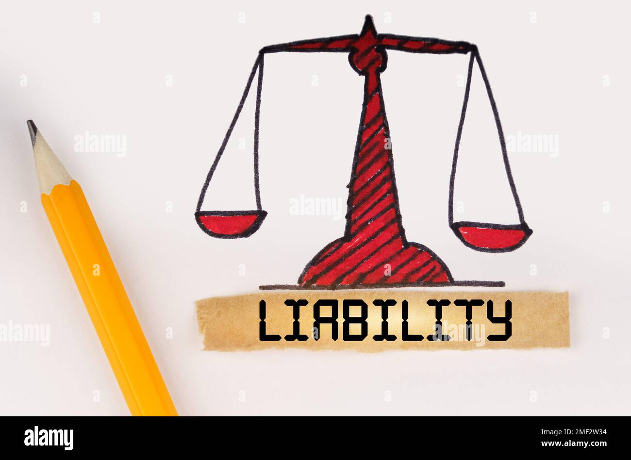 Legal concept. Next to the painted scales of justice lies a pencil and a strip of paper with the inscription - Liability Stock Photo