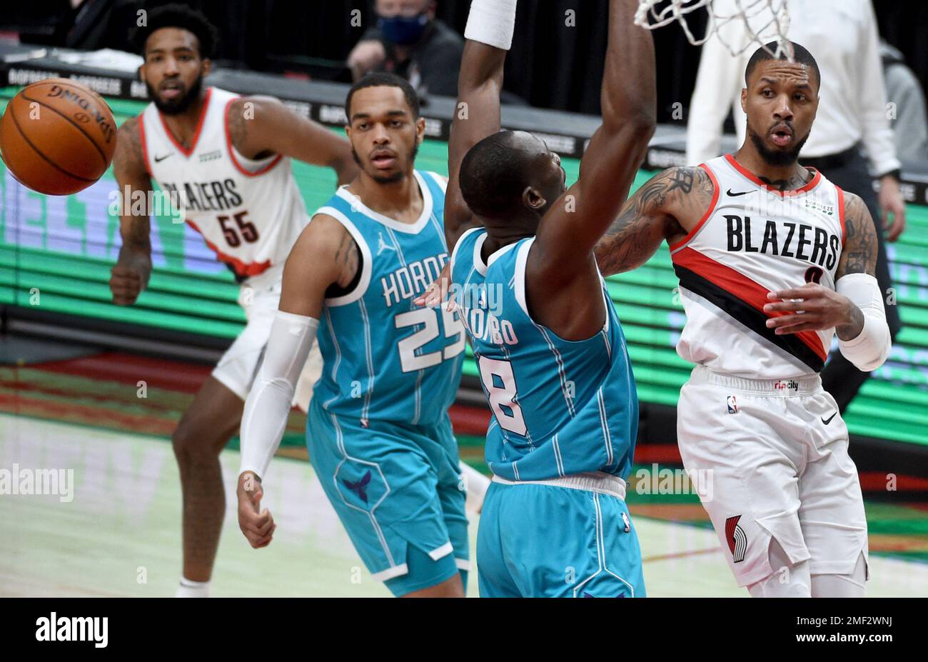 Portland Trail Blazers guard Damian Lillard, right, passes the ball over Charlotte Hornets center Bismack Biyombo, second from right, as Hornets forward P.J