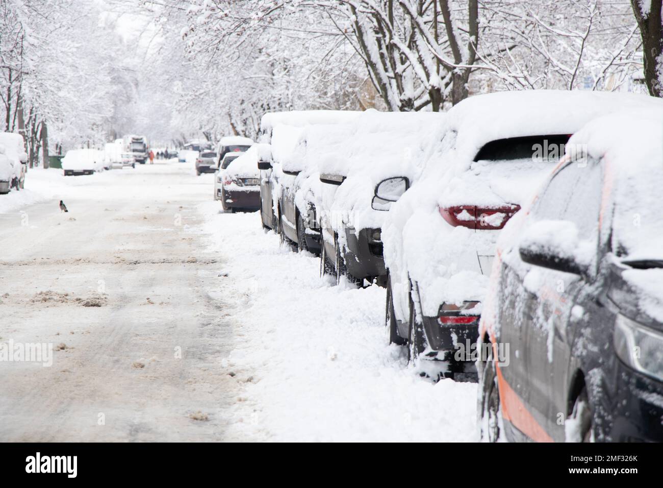 Parked cars along the road in the city center near multi-storey buildings Dnipro city in Ukraine, winter in the city 2021 Stock Photo