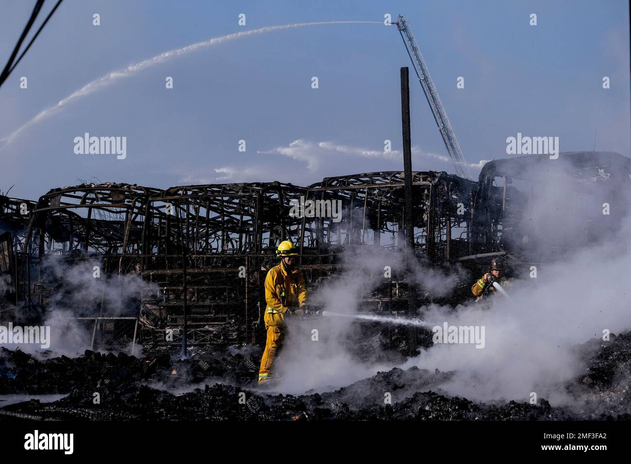 Firefighters battle a fire at a commercial yard in Compton, Calif., on ...