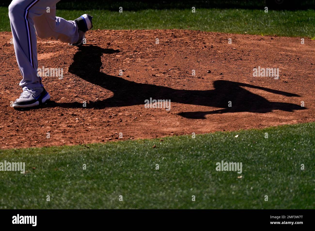 Texas Rangers pitcher Hans Crouse casts a shadow as he throws during ...