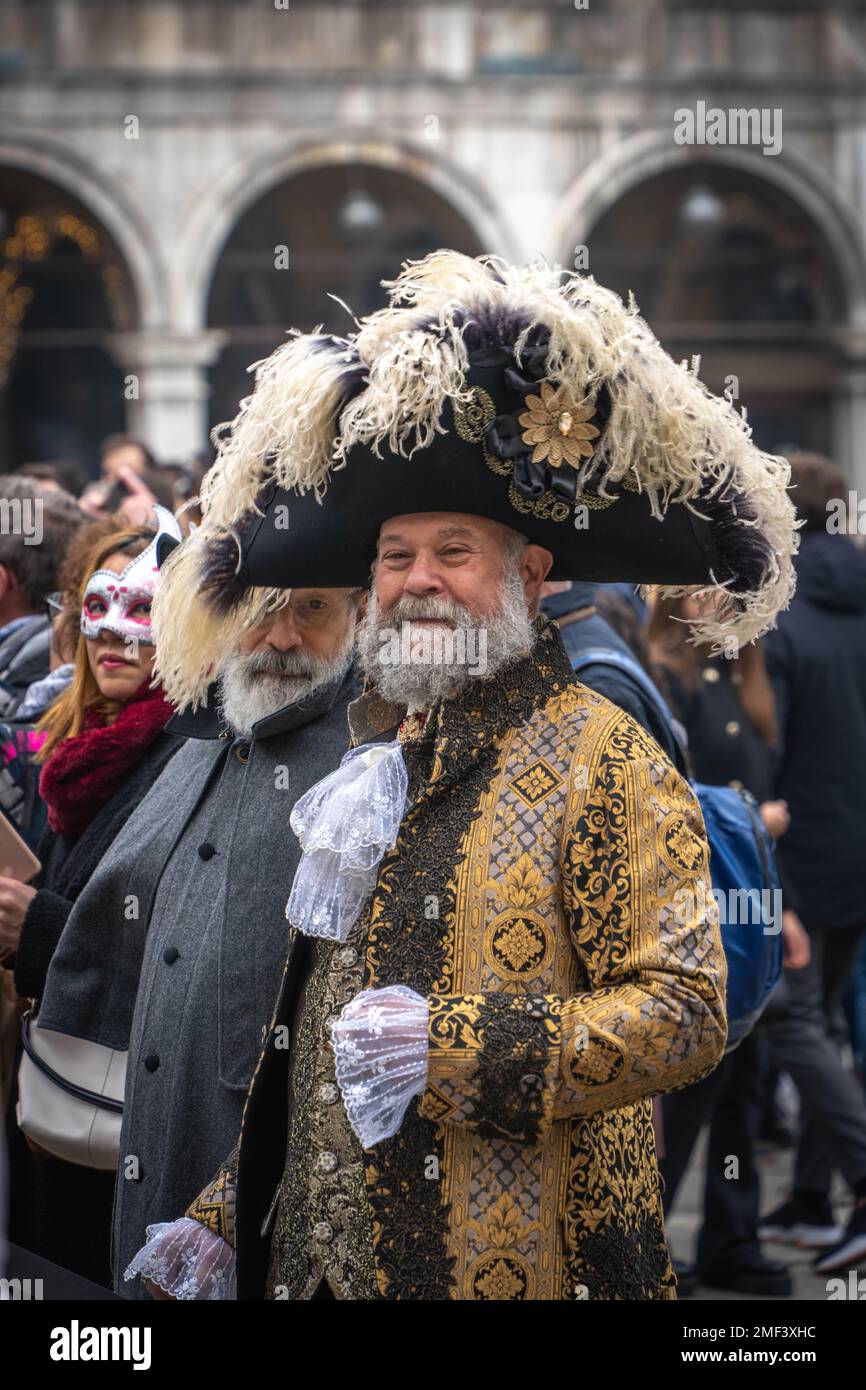 Bearded gray-haired senior man in a big carnival tricorn hat and medieval costume at the carnival in Venice Stock Photo