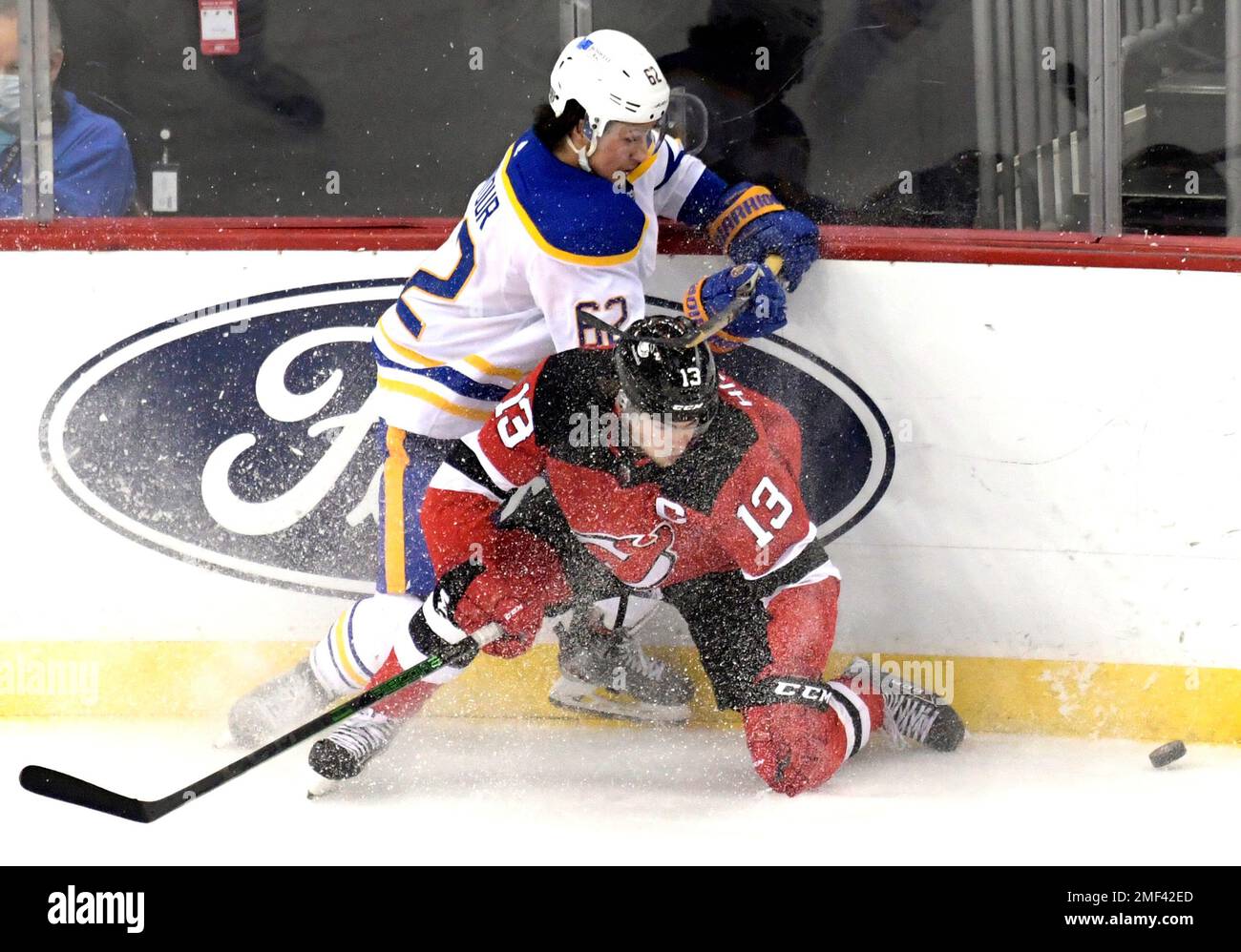 Buffalo Sabres defenseman Brandon Montour (62) checks New Jersey Devils  center Nico Hischier (13) during the third period of an NHL hockey game  Tuesday, Feb. 23, 2021, in Newark, N.J. The Sabres