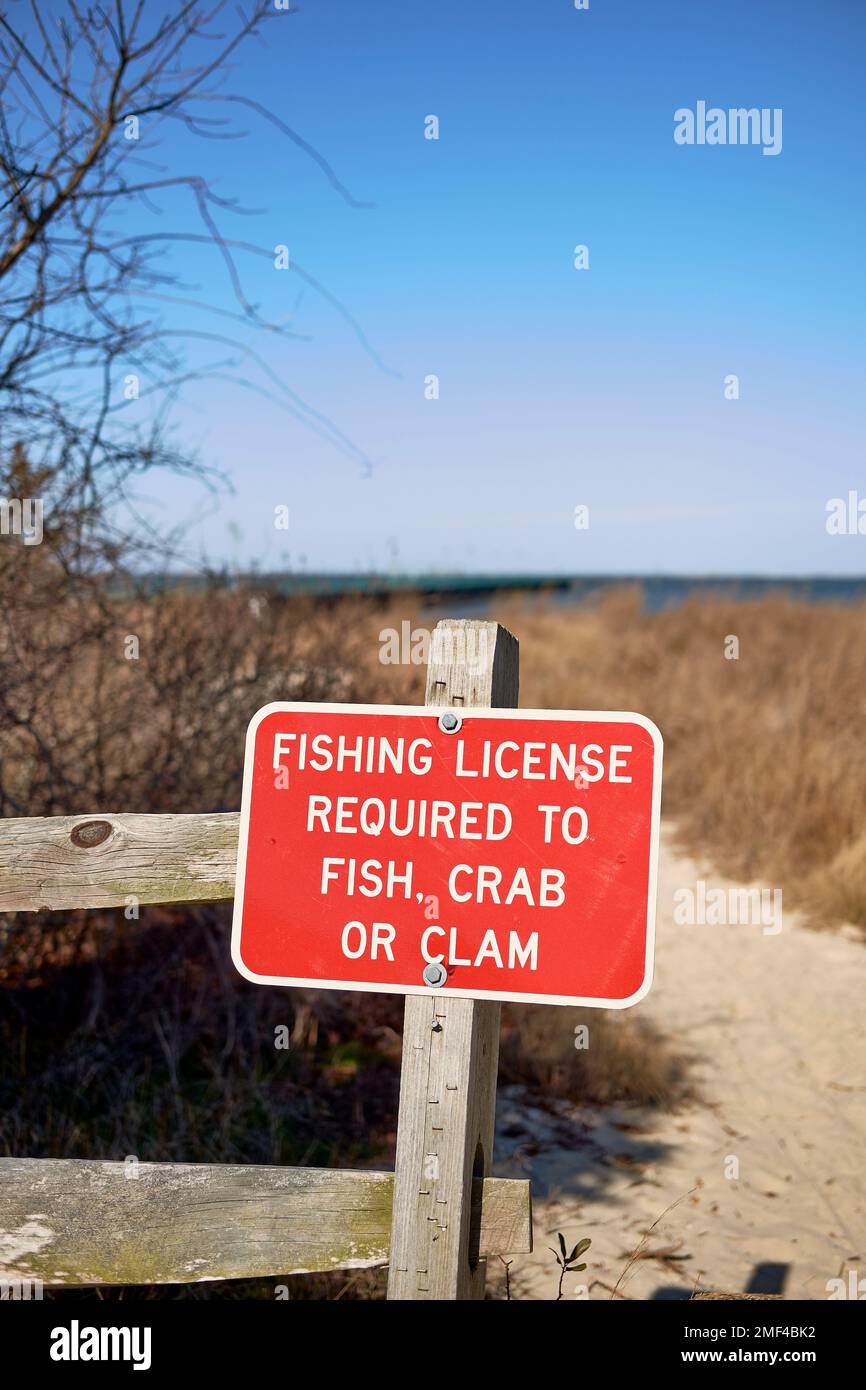 Red fishing license sign regulating fishing, clamming, and crabbing