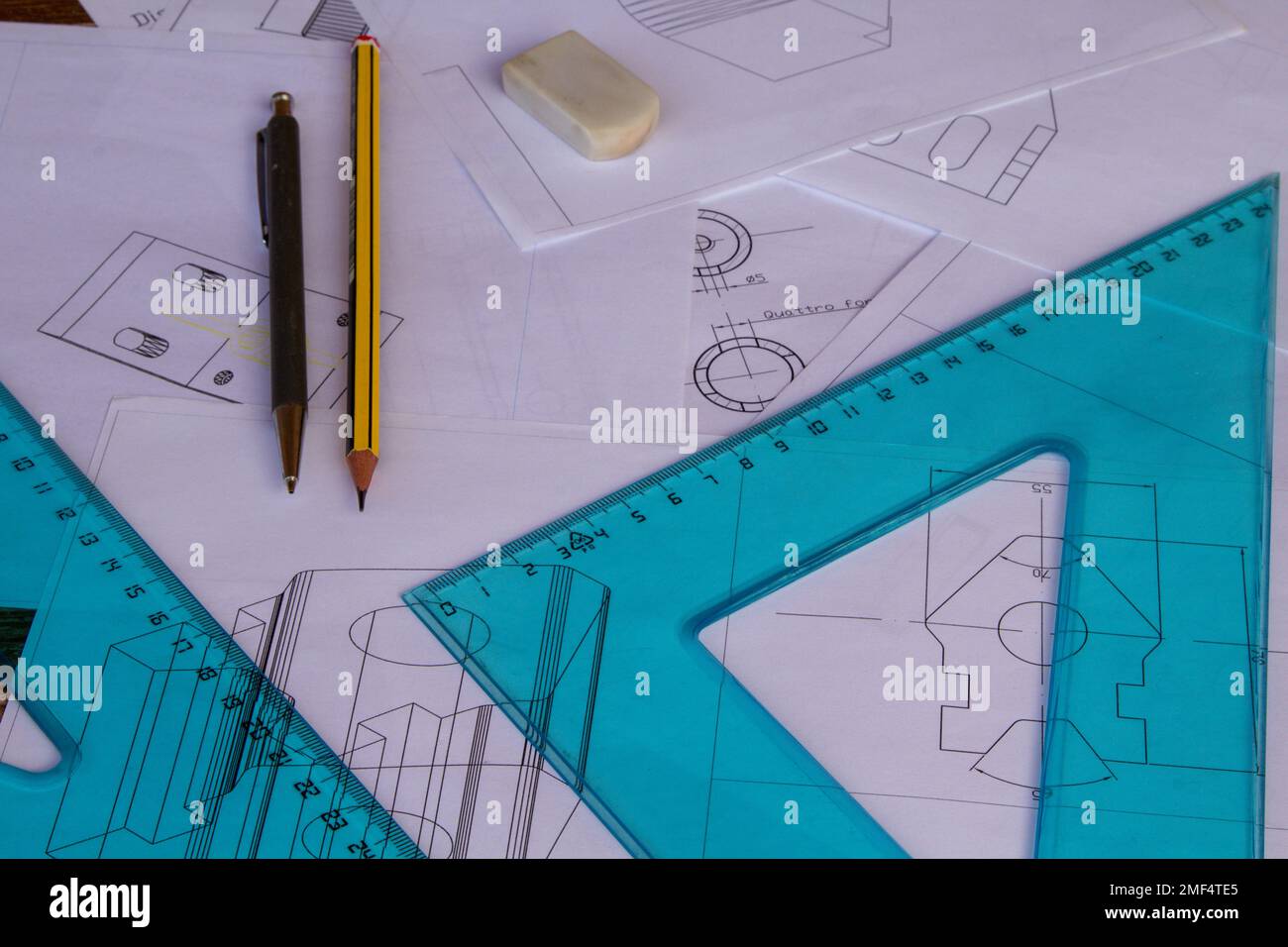 Image of an engineer's table with plans drawn with cad with ruler, set squares and drawing pencils in the background. Stock Photo