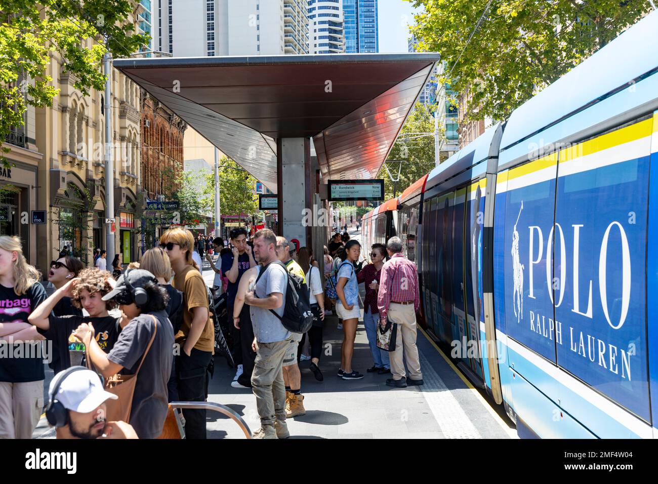 Sydney light rail station stop in Chinatown on street, passengers await to board the