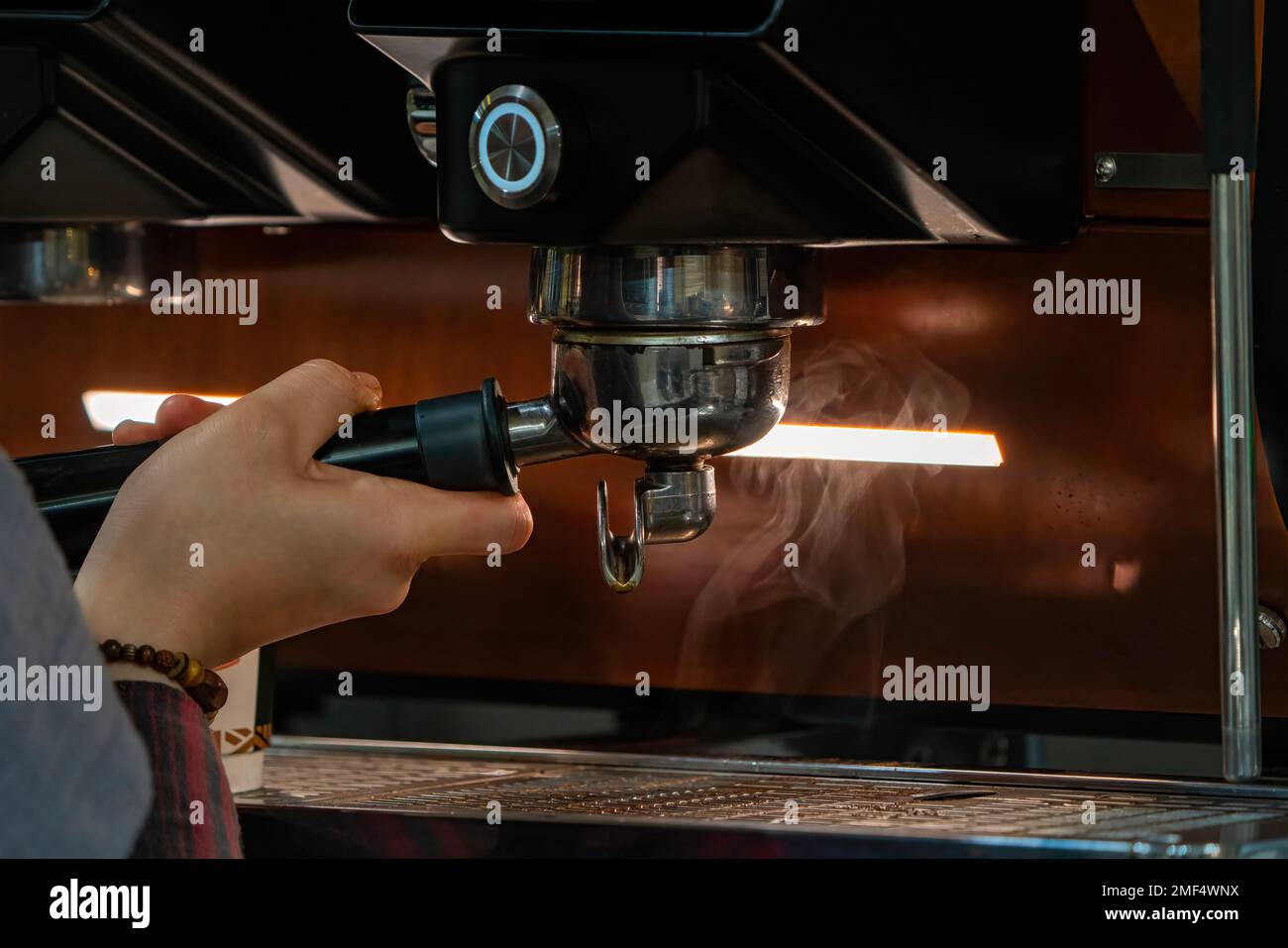 Barista frothing milk to make coffee. Barista hands in front of coffee