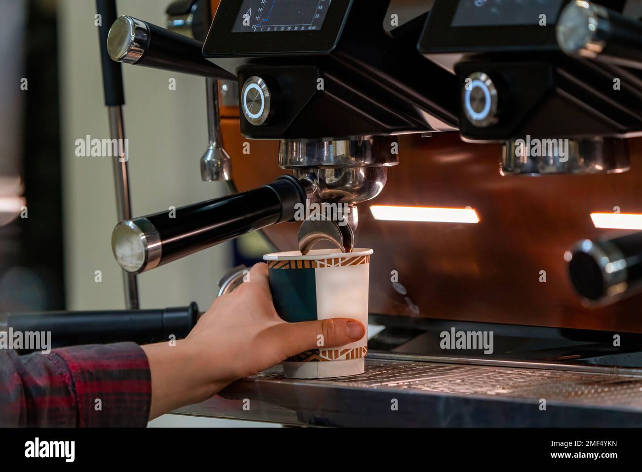 Barista frothing milk to make coffee. Barista hands in front of coffee