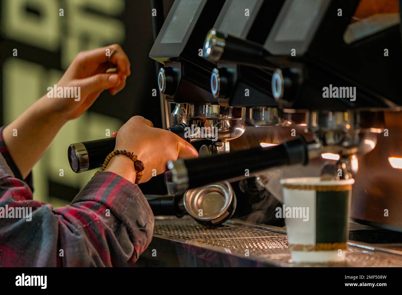 Barista frothing milk to make coffee. Barista hands in front of coffee