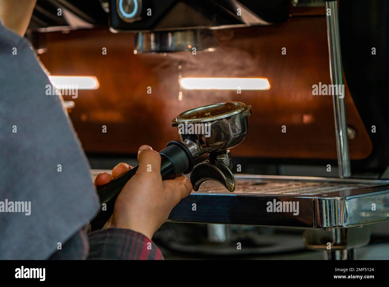 Barista frothing milk to make coffee. Barista hands in front of coffee