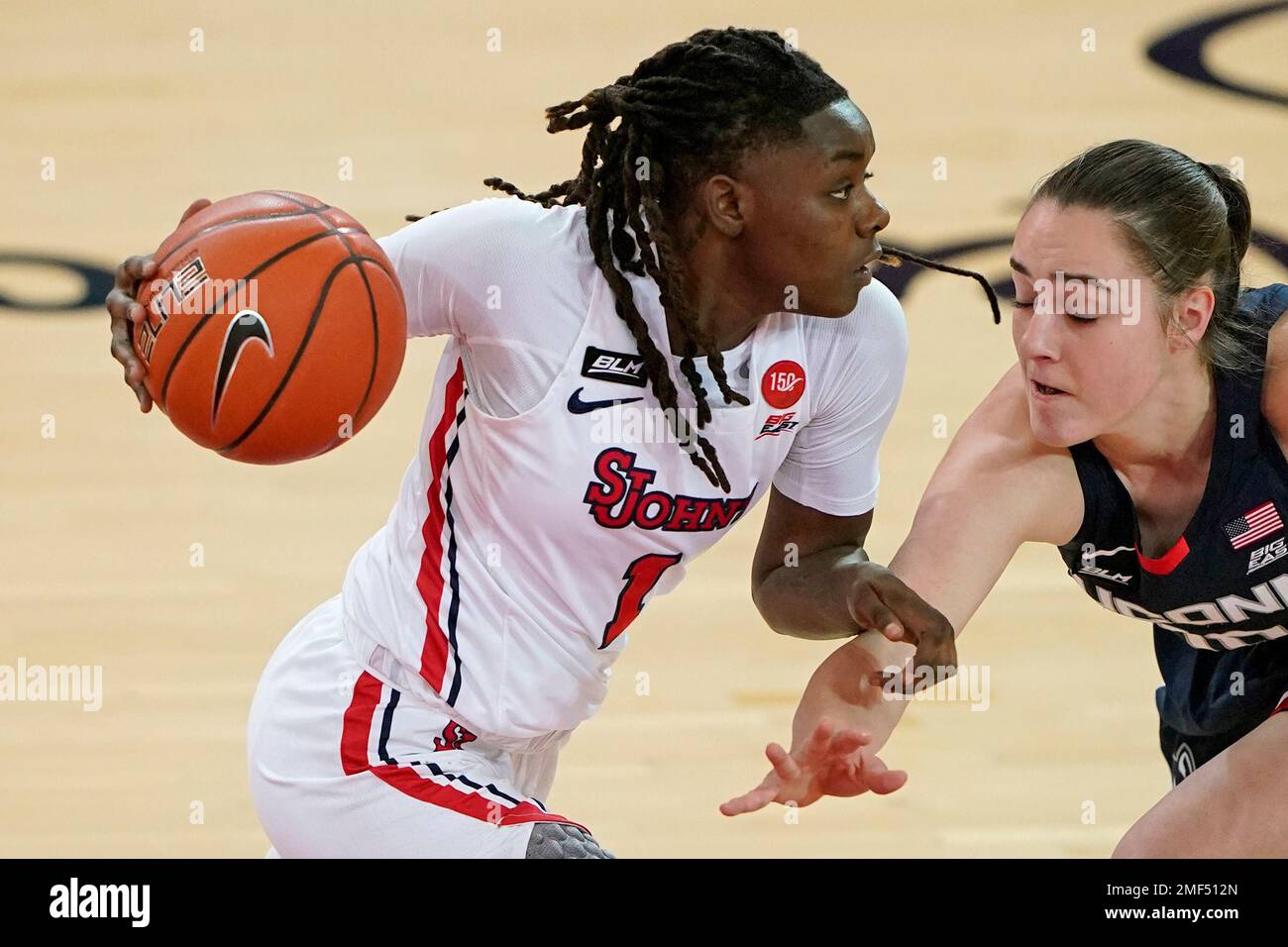 St. John's guard Unique Drake (1) drives against Connecticut guard Nika  Muhl (10) during the second quarter of an NCAA college basketball game,  Wednesday, Feb. 17, 2021, at St. John's University in