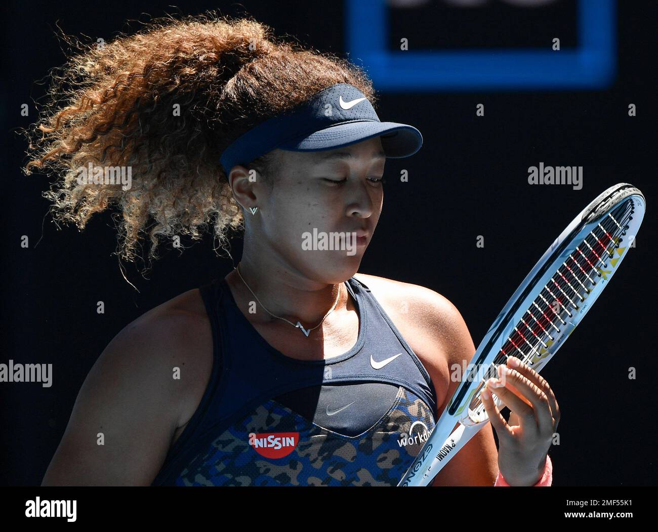Japan's Naomi Osaka adjusts her racket strings during her semifinal