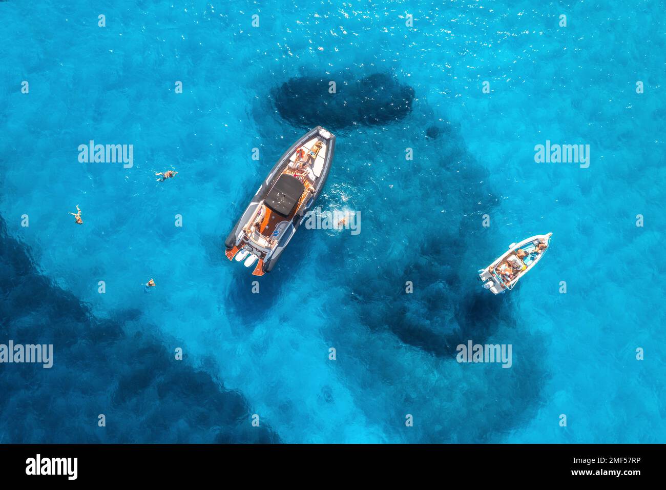 Aerial view of yachts and swimming people in blue sea at sunset Stock ...
