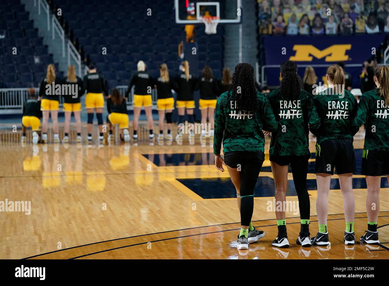 Some Michigan women basketball team members kneel during the national