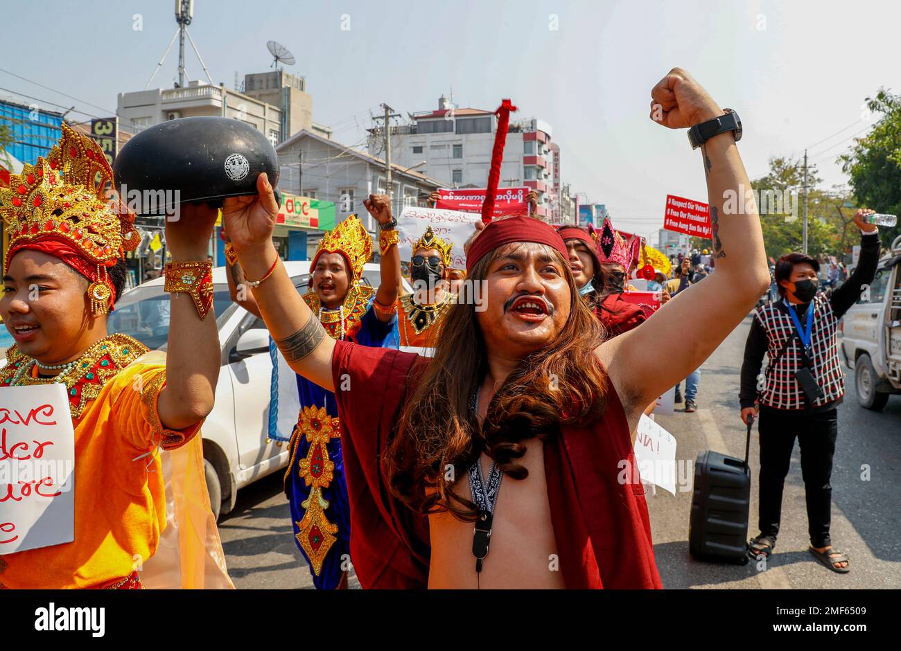 Demonstrators in traditional dance costumes display an upside down