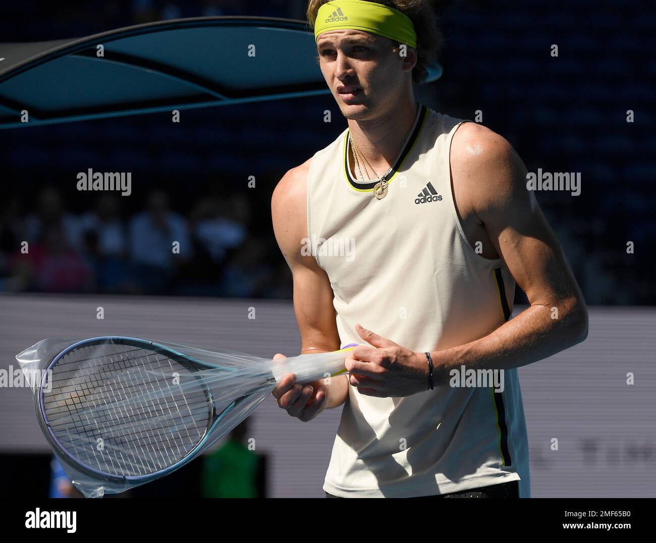 Germany's Alexander Zverev unwraps a newly strung racket during his