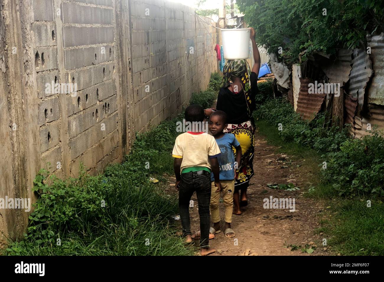 A woman carries a bucket of water on her head in the Bandrajou district