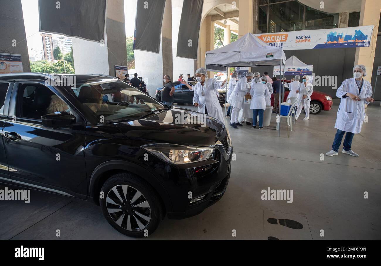 Health workers guide drivers to shots of China's Sinovac CoronaVac