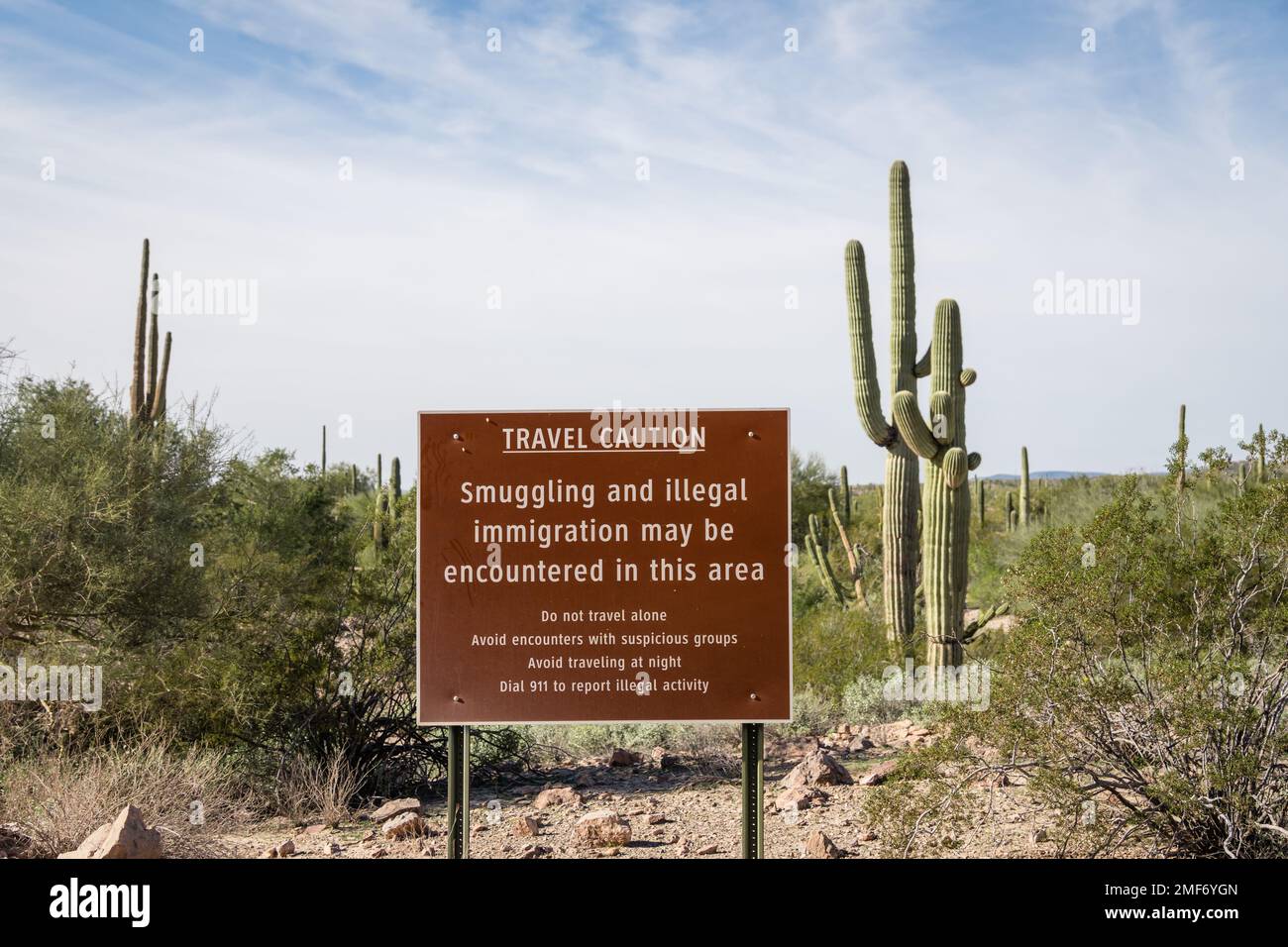 Sign near US - Mexican border wall reading Caution smuggling and illegal immigration in this area - Arizona Stock Photo