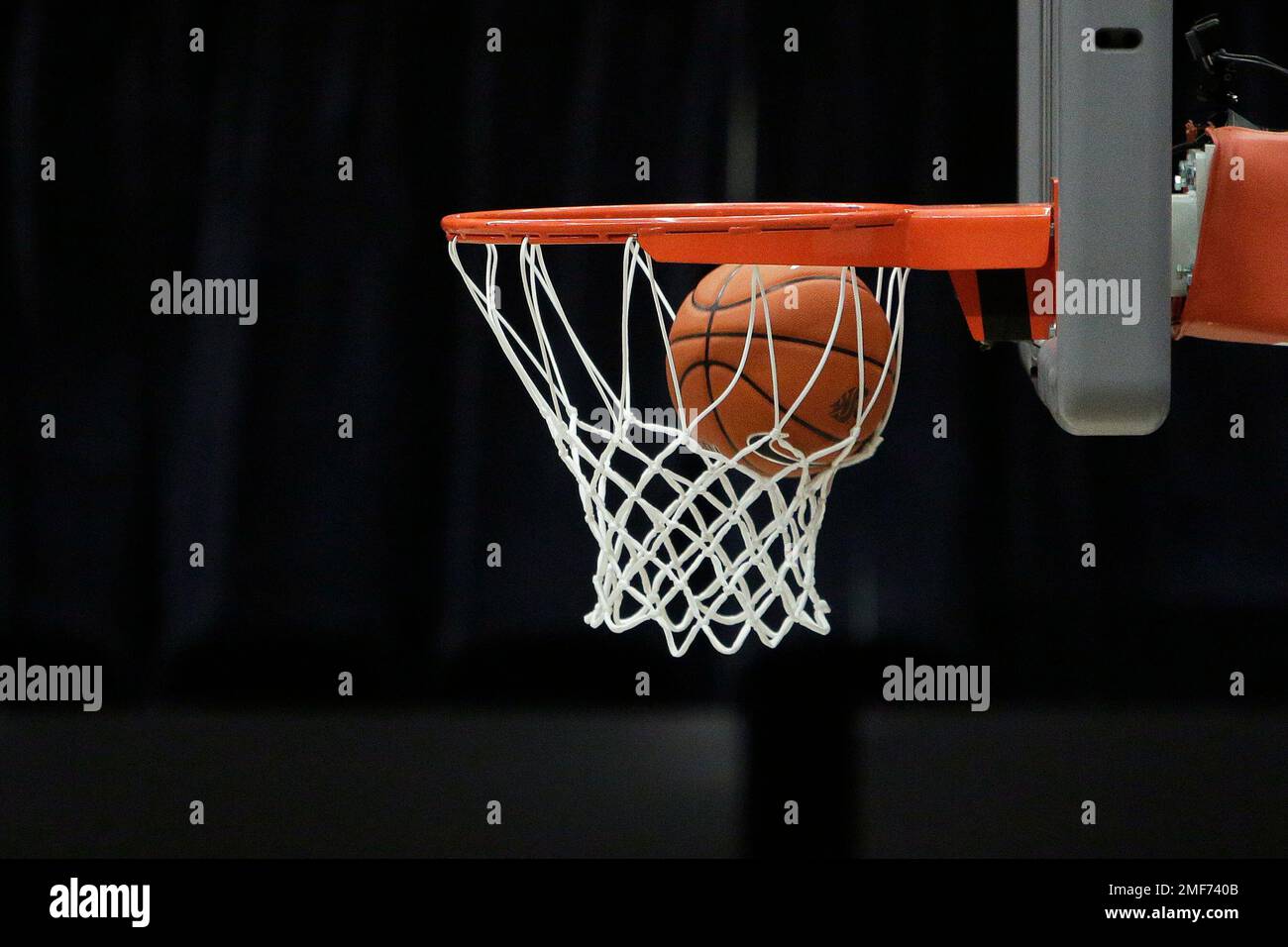 A basketball goes through the hoop during the first half of an NCAA