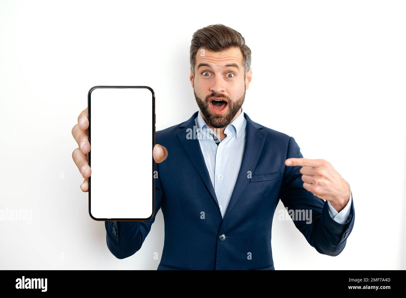 Shocked Amazed Surprised Caucasian Business Man In A Suit Showing Smart Phone With Empty Mock