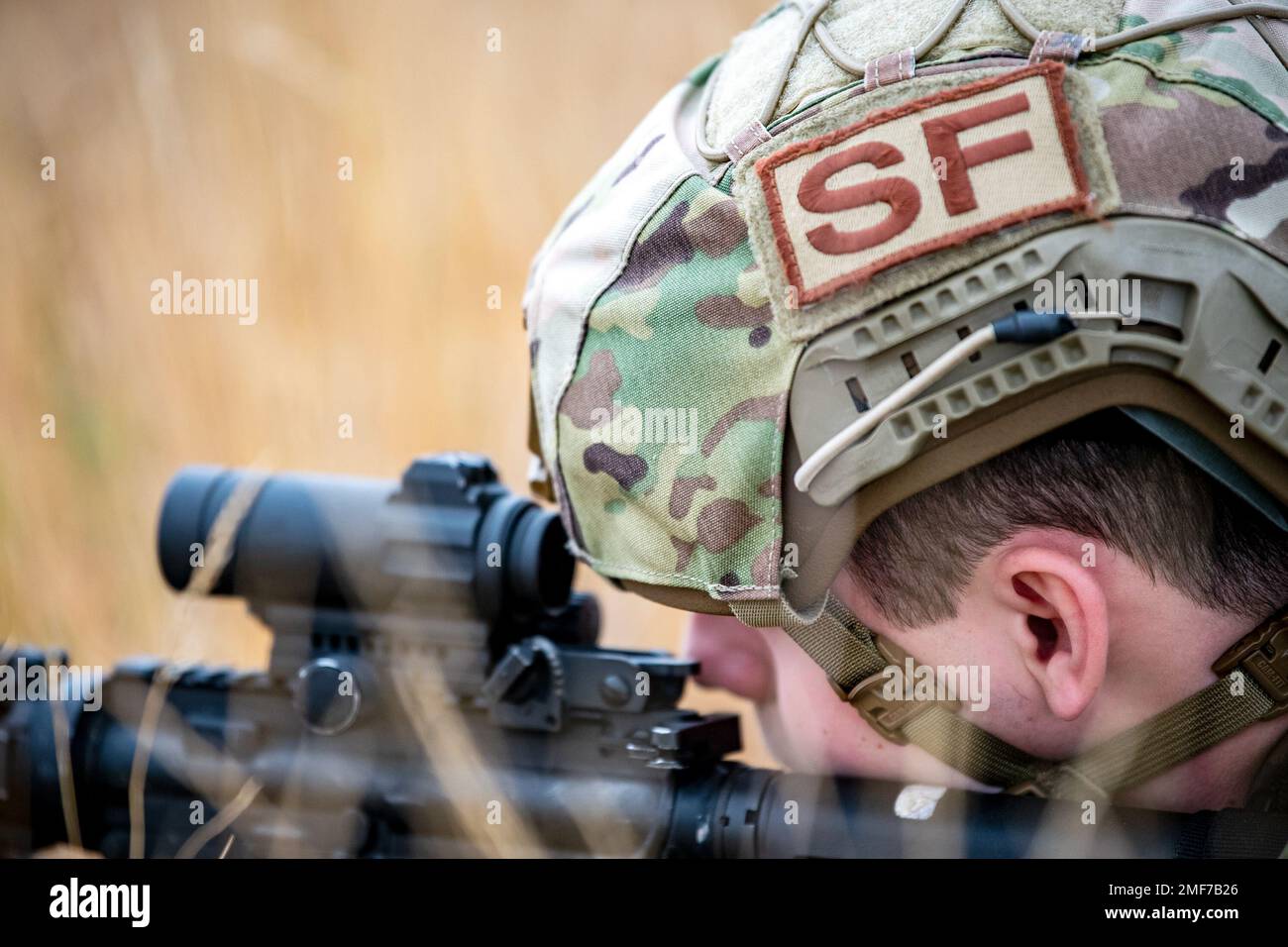An Airman from the 423d Security Forces Squadron looks down the sight of an M4 carbine during a field training exercise at Stanford Training Area, England, Aug. 17, 2022. Instructors from the 820th Base Defense Group and 435th Security Forces Squadron Ground Combat Readiness Training Center, conducted the exercise to evaluate and bolster the combat readiness skills of the defenders from the 423d SFS. Stock Photo