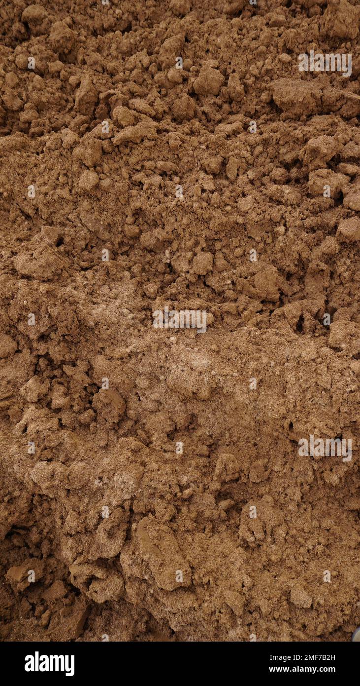 Closeup of macro view of red dirt or mud of pile soil from agriculture