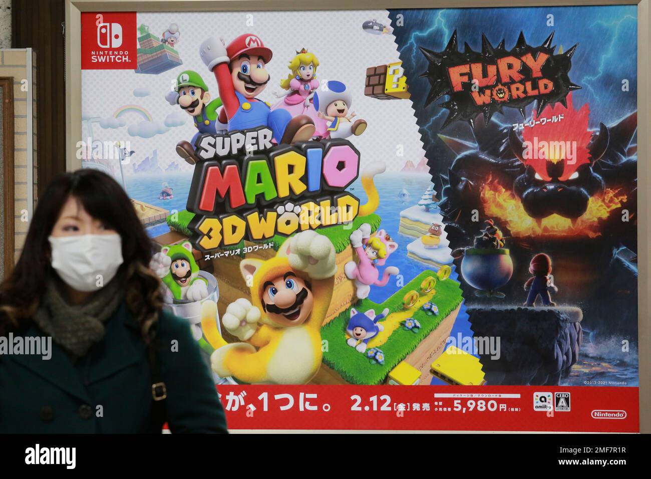A woman walks by posters of Nintendo in Tokyo, Monday, Feb. 1, 2021