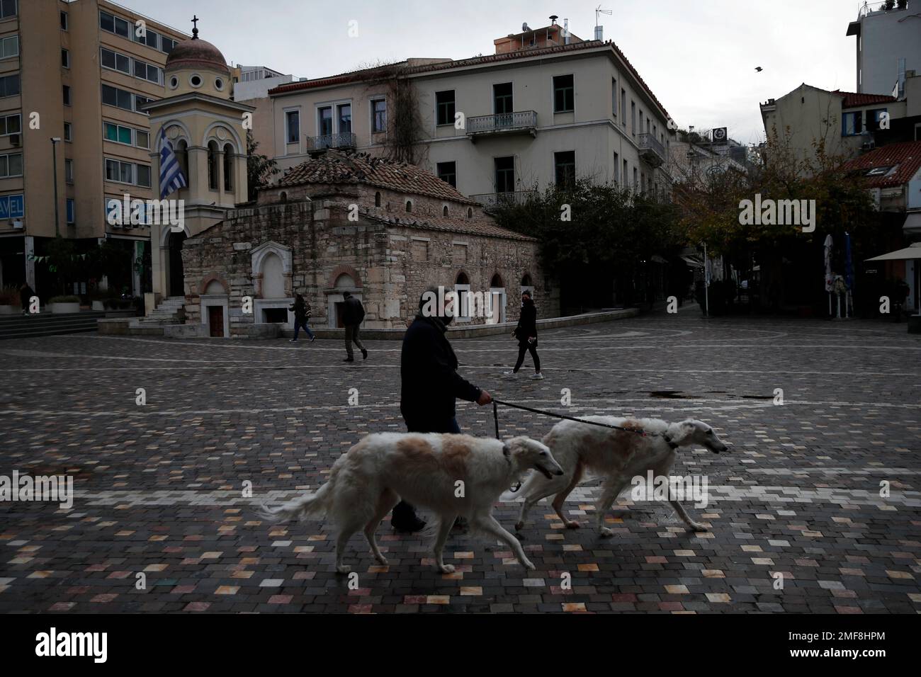 A man wearing a face mask walks his dogs at Monastiraki square in central  Athens, Tuesday, Jan. 26, 2021. (AP Photo/Thanassis Stavrakis Stock Photo -  Alamy