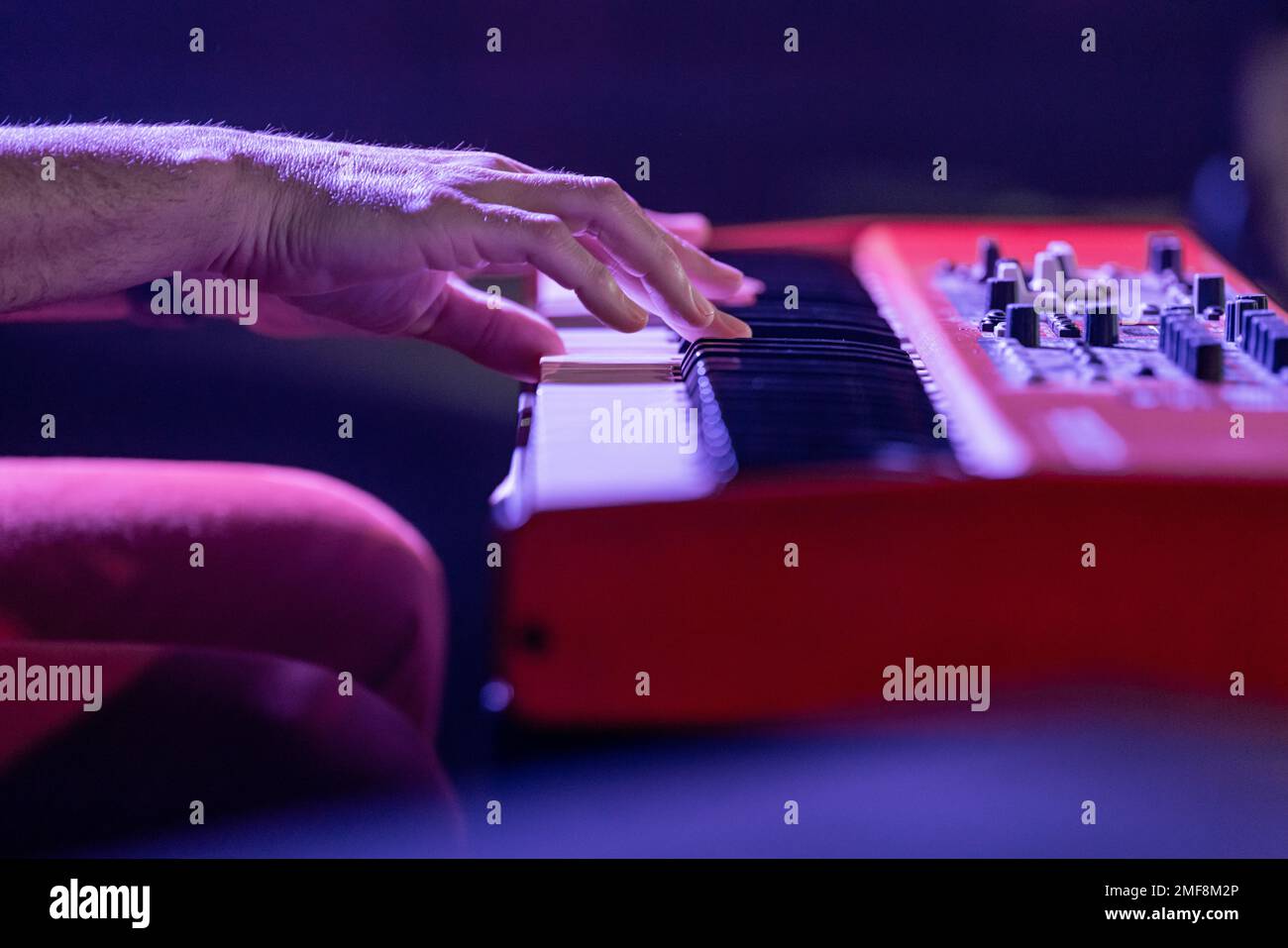 Musician's hands playing an electronic keyboard, synthesizers, at a concert stage. Very shallow depth of field. Stock Photo