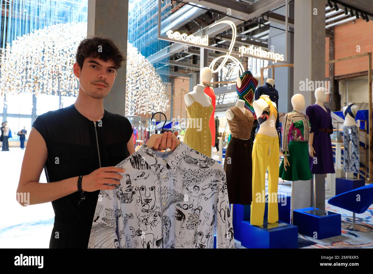 A male salesperson showing vintage clothes to customer in 2e Printemps (Second Printemps) the secondhand clothes and accessories store in 7ieme Ciel (Seventh Heaven) of seventh floor of Au Printemps Haussmann department store.Paris.France Stock Photo