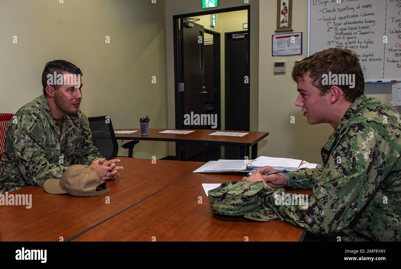 Lt. Cmdr. Jordan Ferris, a chaplain assigned to Commander, Fleet Activities Sasebo (CFAS), speaks with Fireman Luke Day at a simulated emergency family assistance center in the CFAS Fleet and Family Support Center during Exercise Citadel Pacific 2022 (CP22) Aug. 18, 2022. CP22 is an annual exercise that is not in response to any specific real-world threat but is used to evaluate the readiness of fleet and installation security programs. Stock Photo