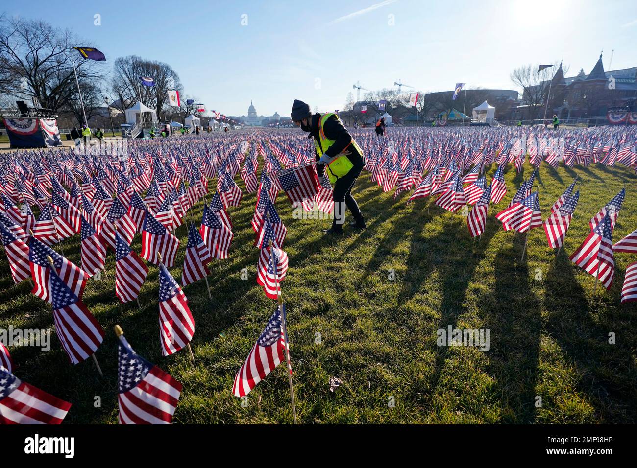 Workers begin to remove a display of flags on the National Mall one day ...