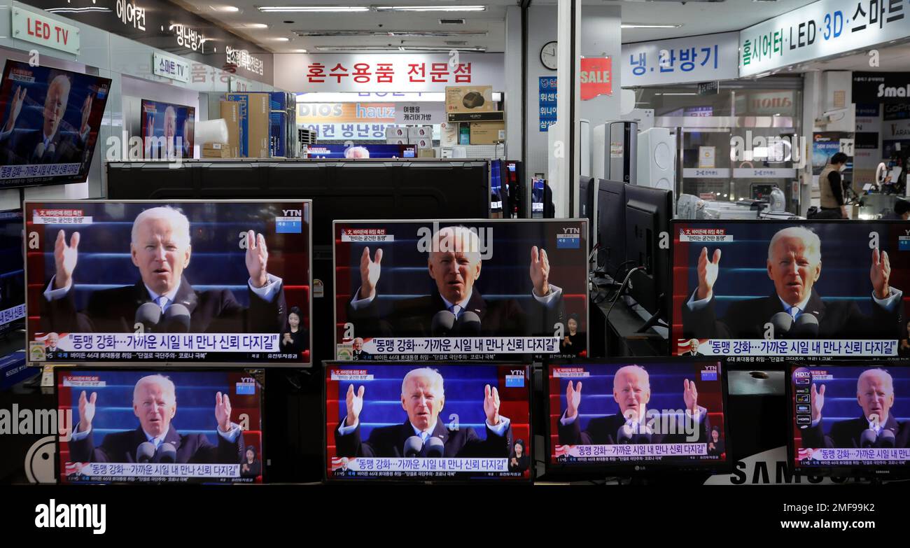 A man stands near tv screens showing a news program reporting about u s